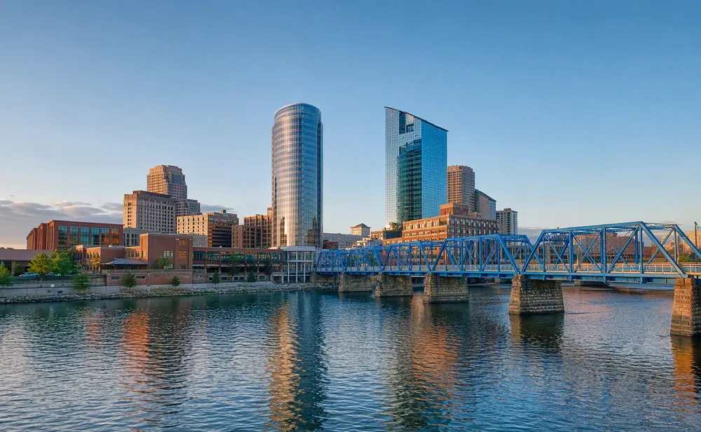 Downtown Grand Rapids skyline at dusk with the Santa Fe Building rising over the Grand River valley